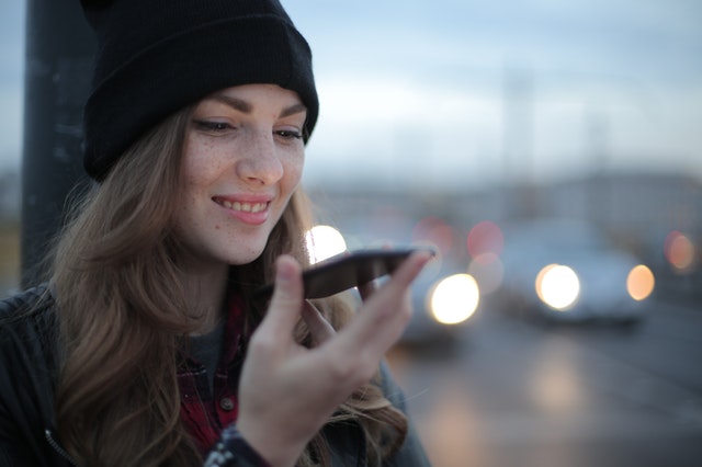 woman smiling and speaking into a phone