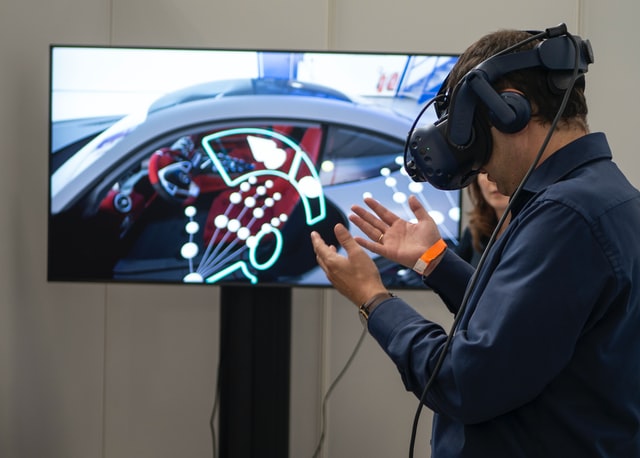 man wearing a VR headset and virtually experiencing a car 