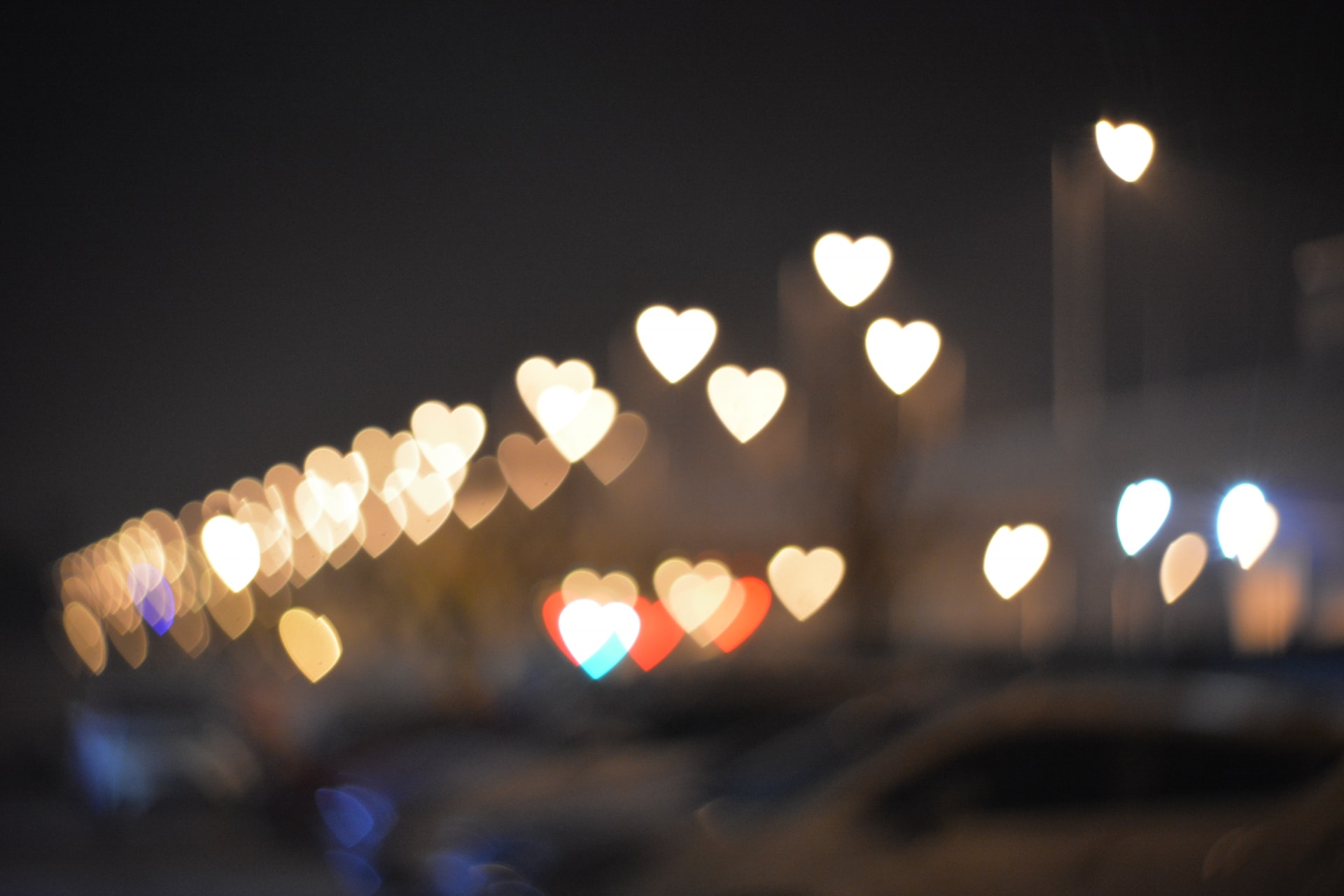 Heart-shaped lights in a variety of colors on a dark background