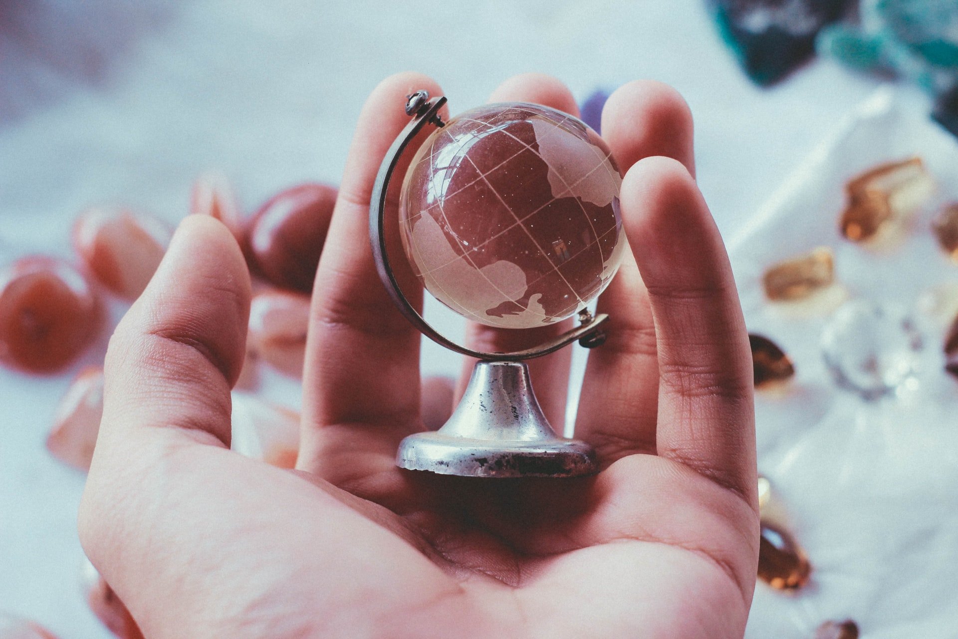 A person holding a small globe in their hand