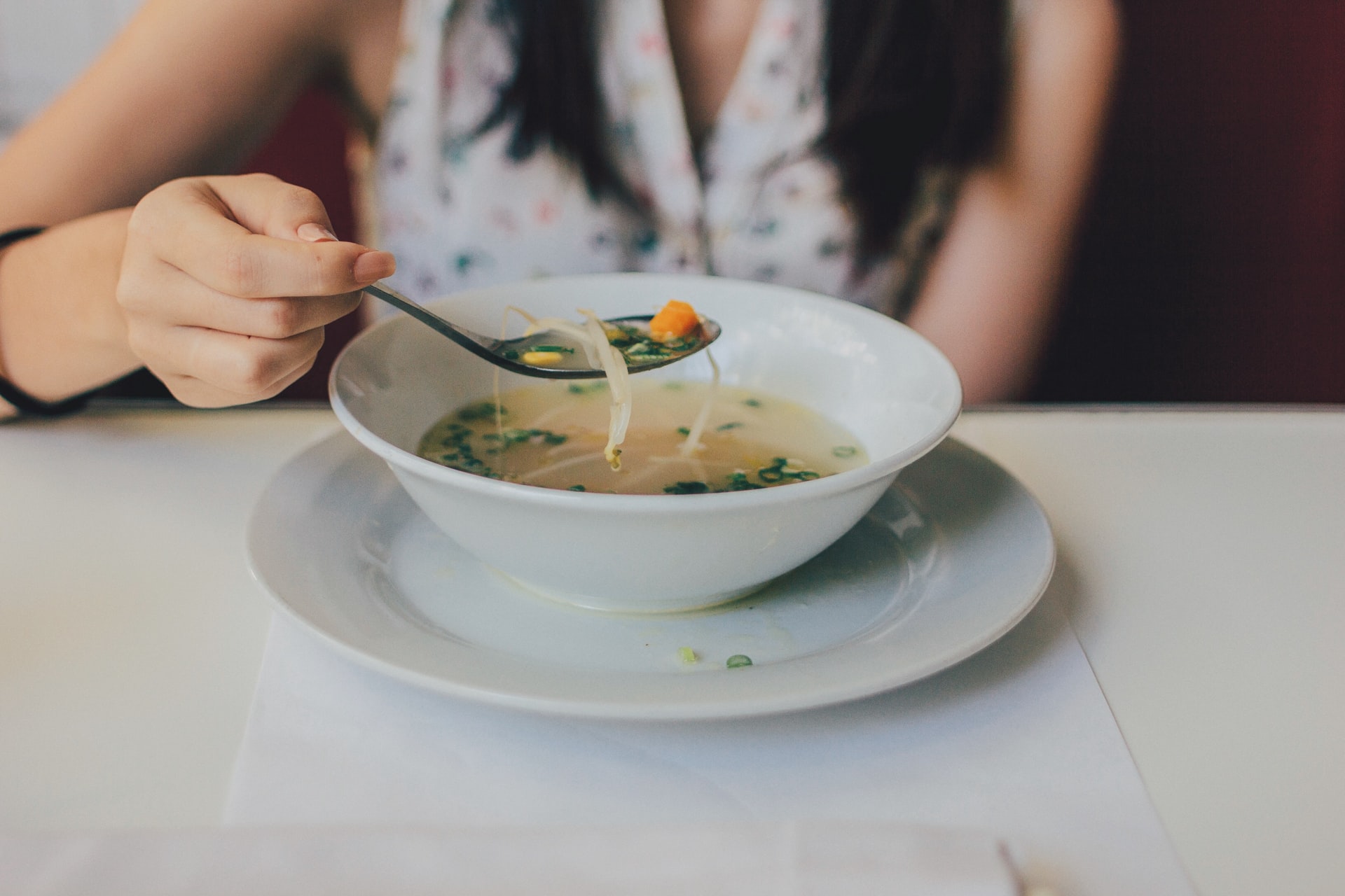 A person eating soup with a spoon