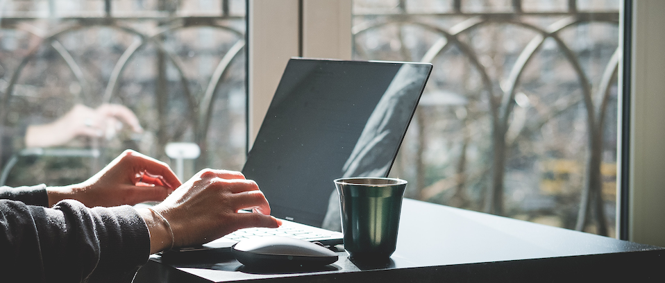 A laptop and a computer monitor on a wooden desk