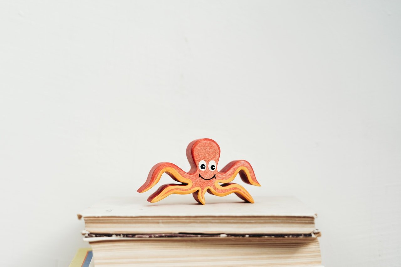 Octopus on a pile of books: Octopuses are smart, but they can't manage knowledge like humans do.