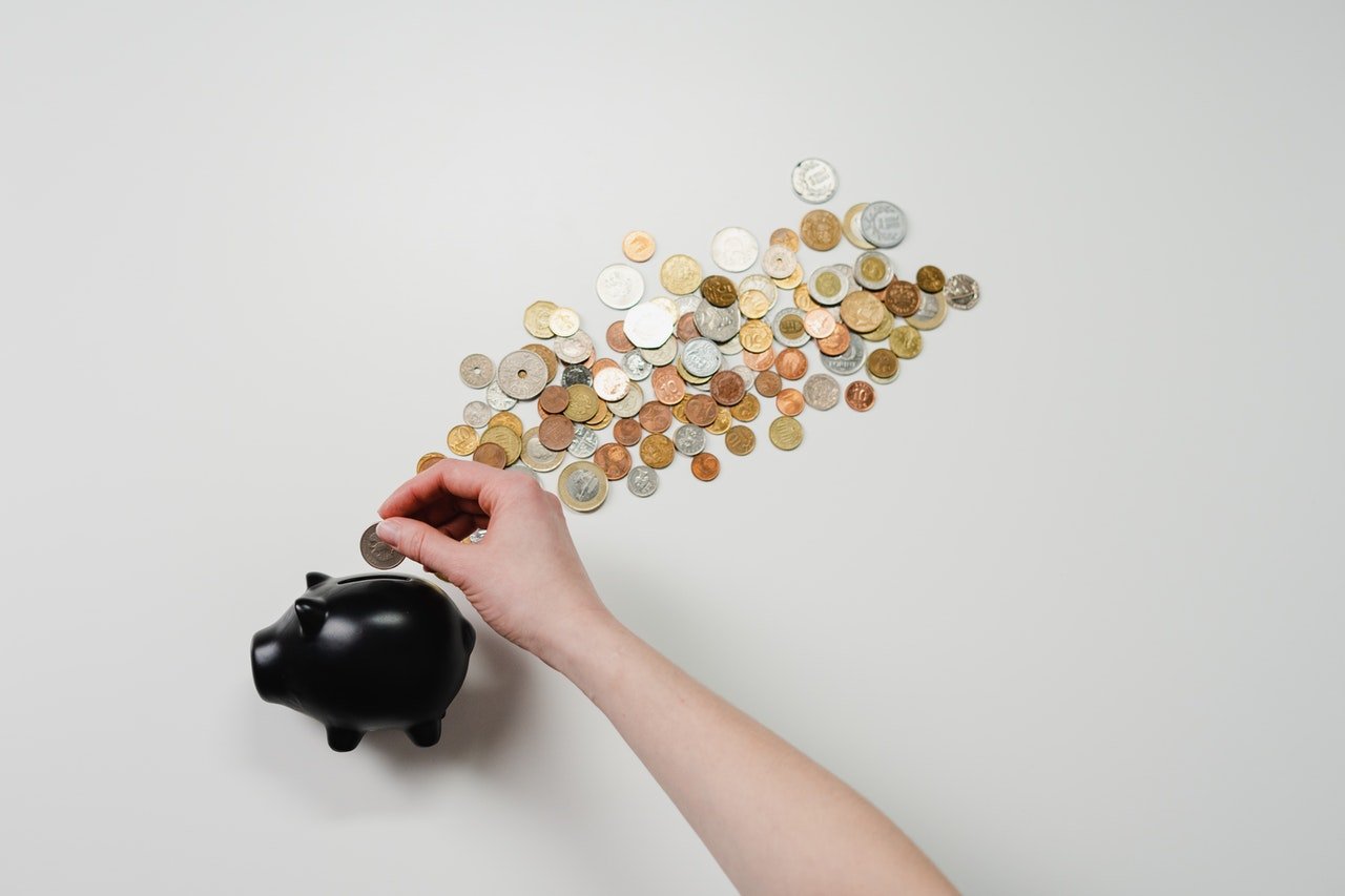 A person putting coins into a piggy bank 