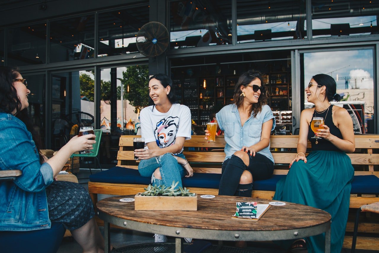 Four people sitting outside with beverages