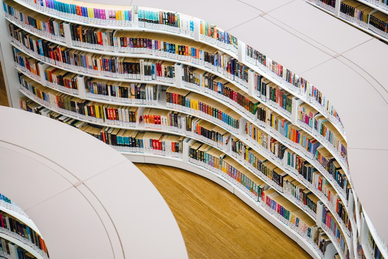 colourful books on white shelves 