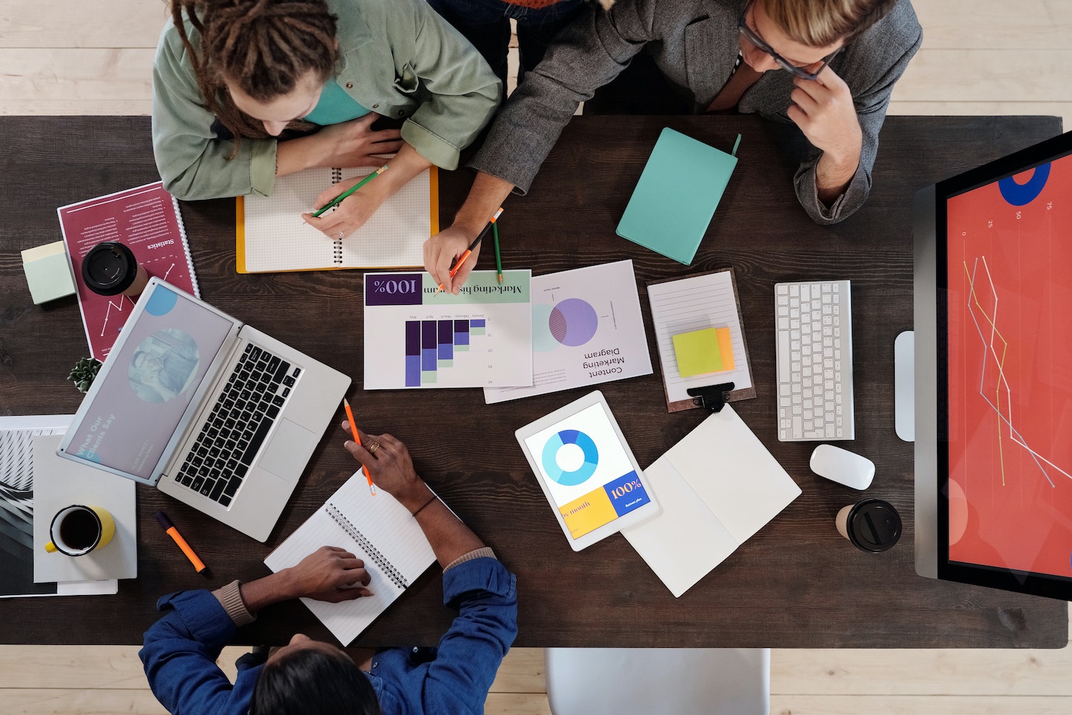 people working together at a table with data and research