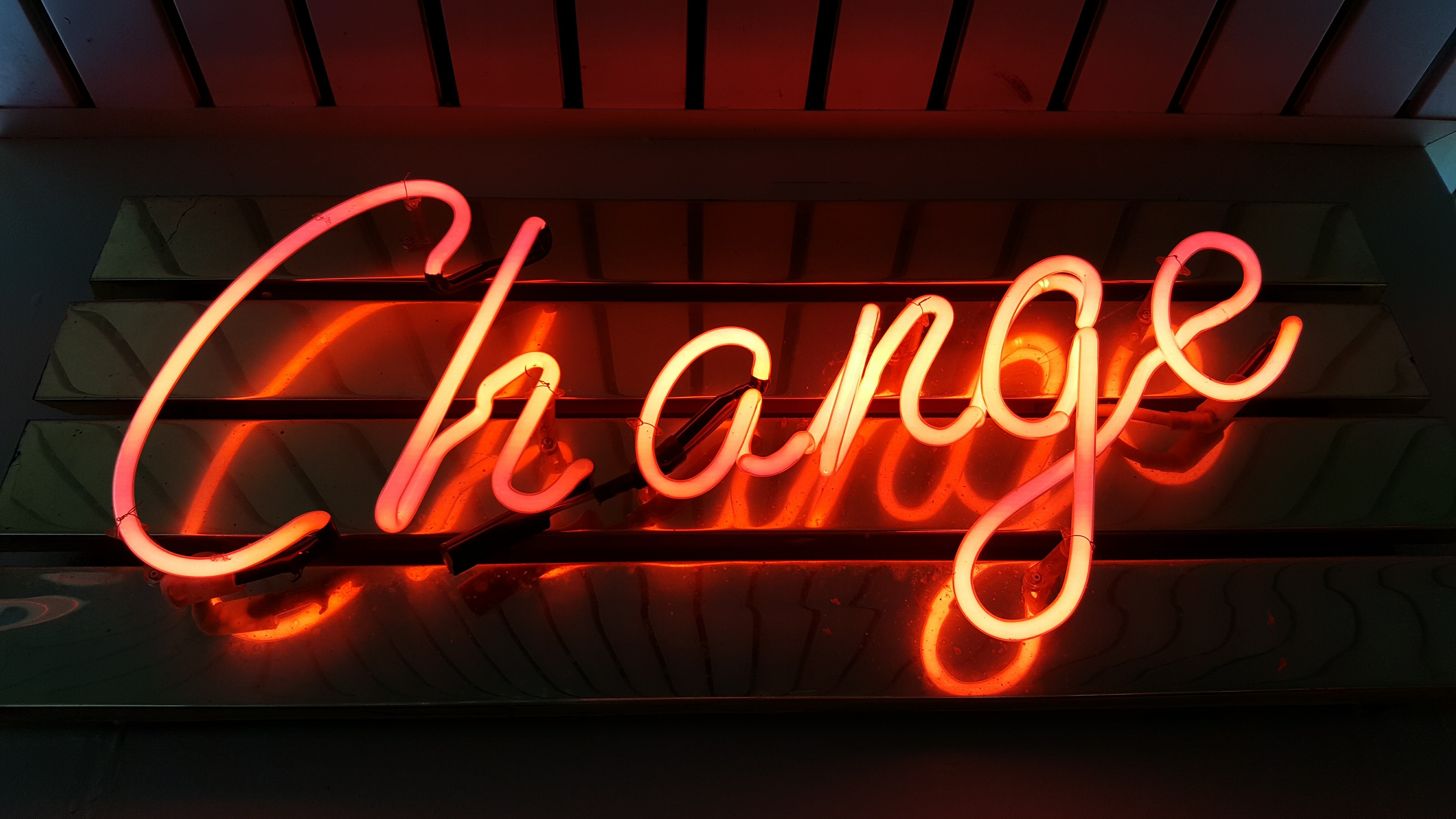 Orange neon letter sign that says Change